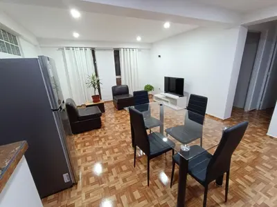 a living room with chairs and a table and a tv at Apartamento en Cusco IV in Cusco