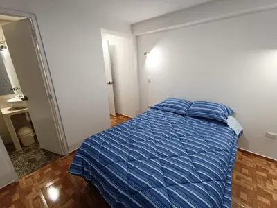 a bedroom with a bed with a blue comforter at Apartamento en Cusco IV in Cusco