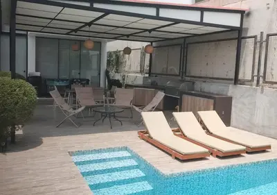 a patio with chairs and a table and a pool at Maya House Cieneguilla in Cieneguilla