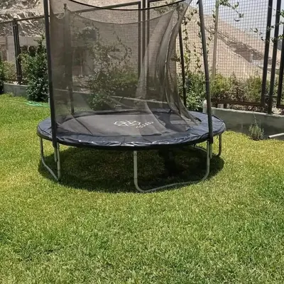 a trampoline with a net on the grass at Maya House Cieneguilla in Cieneguilla