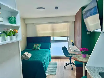 a small bedroom with a blue bed and a desk at Bertolotto, divino minidepa smartv wifi y amoblado in Lima