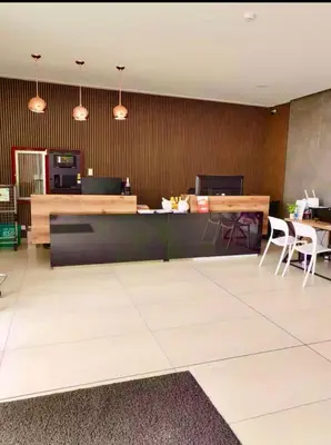 a lobby with a counter with chairs and a table at Bertolotto, divino minidepa smartv wifi y amoblado in Lima