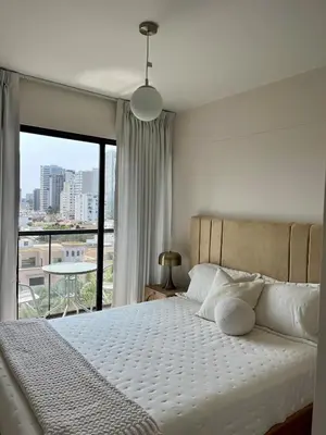 a bedroom with a bed and a large window at Great 1BR in San Isidro in Lima