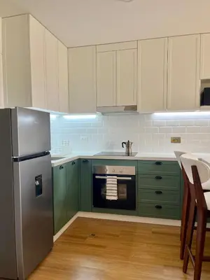 a kitchen with green cabinets and a stainless steel refrigerator at Great 1BR in San Isidro in Lima