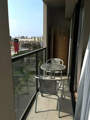 a table and chair on a balcony with a view of a city at Great 1BR in San Isidro in Lima