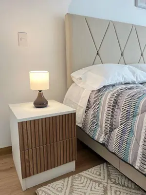 a bed with a table with a lamp on it at Entire apartment minutes from Miraflores in Lima