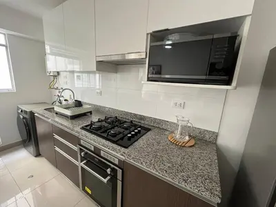 a kitchen with a stove and a sink and a microwave at Entire apartment minutes from Miraflores in Lima