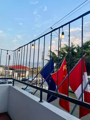 two flags on a balcony with a view of a parking lot at Hotel Naciones Unidas in Lima
