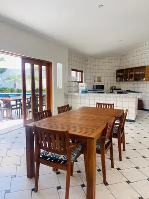 a wooden table and chairs in a kitchen with a view at Casa de Playa en Lobos in Cerro Azul