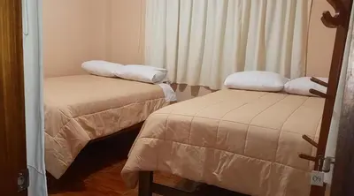 a room with two beds and a window at Echevarria Oxapampa in Oxapampa