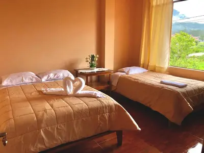 two beds in a room with a window at Echevarria Oxapampa in Oxapampa