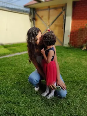a woman kissing a little girl on the grass at Echevarria Oxapampa in Oxapampa
