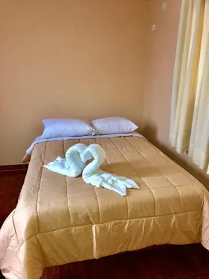 a towel animal is laying on a bed at Echevarria Oxapampa in Oxapampa
