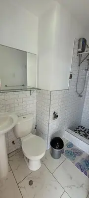 a white bathroom with a toilet and a sink at Bravos Hospedaje Punta Negra in Punta Negra