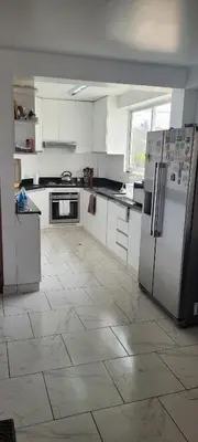 a kitchen with white appliances and a tile floor at Bravos Hospedaje Punta Negra in Punta Negra