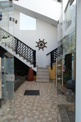 a lobby with stairs and a clock on the wall at Hospedaje Mayo Huacachina in Ica