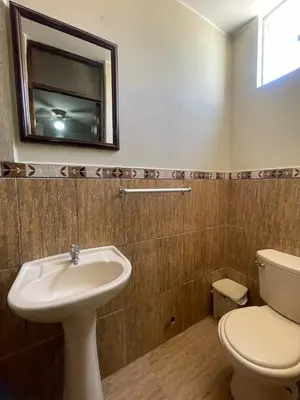 a bathroom with a sink and a toilet and a mirror at Hospedaje Mayo Huacachina in Ica