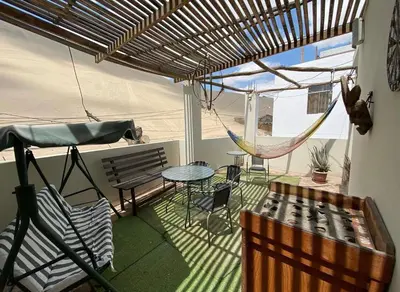 a patio with a hammock and a table and chairs at Hospedaje Mayo Huacachina in Ica