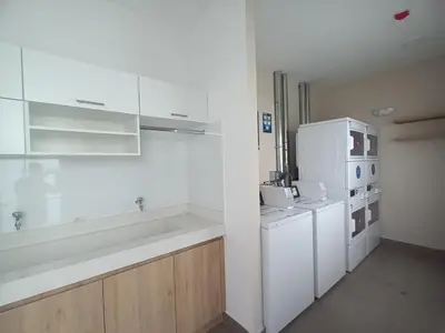 a white kitchen with a refrigerator and a sink at Katty's apartment - Santa Beatriz in Lima