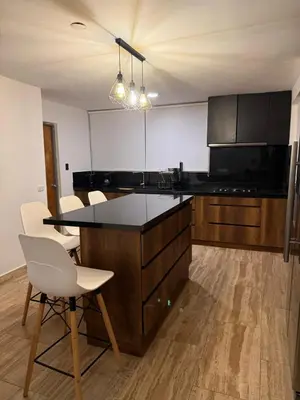 a kitchen with a black counter and white chairs at Welcoming apartment in Lima