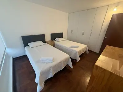 a room with two beds with white sheets at Welcoming apartment in Lima