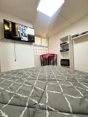 a bedroom with a large bed with a television on the wall at Miraflores, baño privado, ingreso independiente in Lima