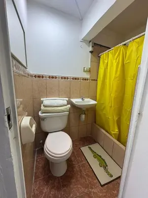 a bathroom with a toilet and a yellow shower curtain at Miraflores, baño privado, ingreso independiente in Lima