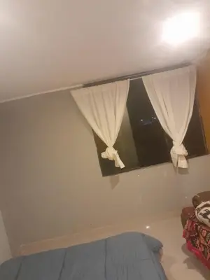 a bedroom with a window with white curtains at HOSTElANDES in San Antonio