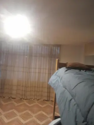 a bedroom with a bed and a light on the ceiling at HOSTElANDES in San Antonio
