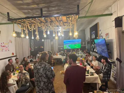 a group of people sitting at tables in a room at Bardak hostel in Cusco