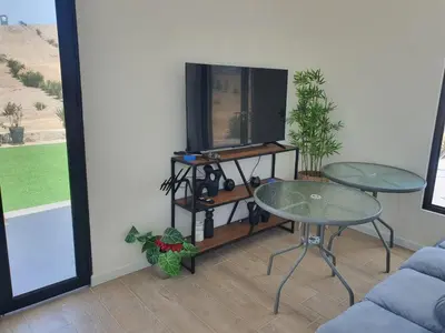 a living room with two tables and a tv at CASA PLAYA con PISCINA in Punta Negra