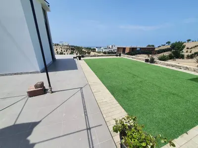 a green lawn on the side of a building at CASA PLAYA con PISCINA in Punta Negra