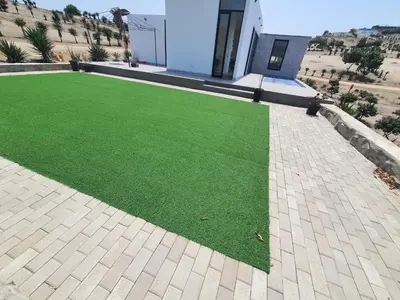 a yard of green grass in front of a house at CASA PLAYA con PISCINA in Punta Negra