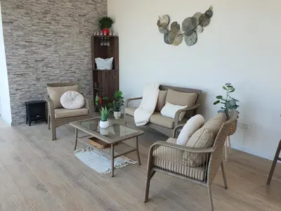 a living room with several chairs and a table at CASA PLAYA con PISCINA in Punta Negra
