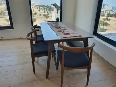 a dining room table and two chairs with a table and window at CASA PLAYA con PISCINA in Punta Negra