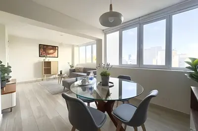 a living room with a glass table and chairs at The 28 Residence Miraflores in Lima