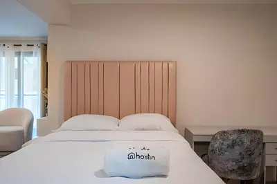 a bedroom with a large white bed with a chair at The Urban Loft in San Miguel in Lima