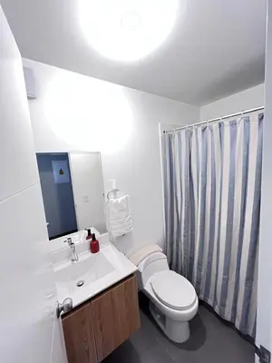 a bathroom with a toilet and a sink and a mirror at La Foret in Lima