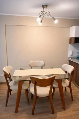a dining room table with chairs and a table and a light at La Foret in Lima
