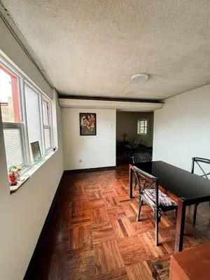 an empty living room with a wooden floor and windows at Miraflores, habitación en apartamento compartido in Lima