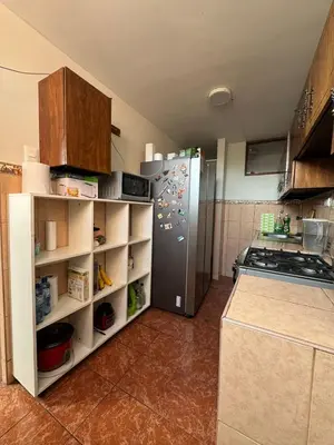a kitchen with a stainless steel refrigerator and shelves at Miraflores, habitación en apartamento compartido in Lima