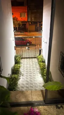 a view of a walkway with a fence and flowers at Miraflores, habitación en apartamento compartido in Lima