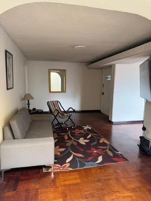a living room with a couch and a rug at Miraflores, habitación Triple en apartamento compartido in Lima