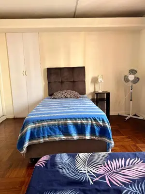 a bedroom with a bed with a blue and white blanket at Miraflores, habitación Triple en apartamento compartido in Lima