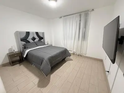 a bedroom with a bed and a flat screen tv at Apartamento moderno a 5 minutos de Plaza Norte in Lima