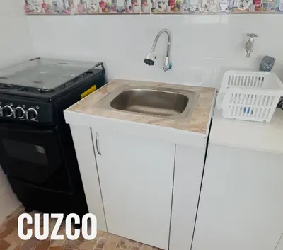 a kitchen with a sink and a stove at Tampumachay in Cusco