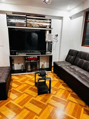 a living room with a black couch and a flat screen tv at Tampumachay in Cusco