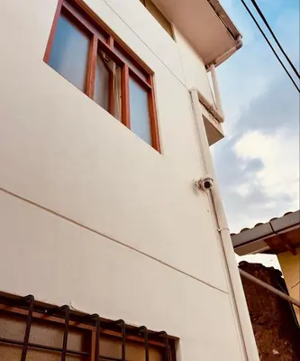 a house with two windows on the side of it at Tampumachay in Cusco
