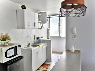 a kitchen with white cabinets and a microwave at Lindo depa cerca a huacachina in Ica