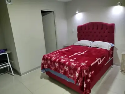 a bedroom with a red bed with a red blanket at Hostal San Ignacio Monterrico in Lima